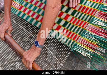 Personnes âgées faisant main vietnamiens reed colorés de tapis. Banque D'Images