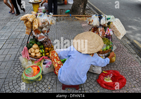 Commerçant de la rue de sexe féminin vente de fruits, noix, etc. en sac à l'adoption du commerce de Ho Chi Minh Ville, Vietnam Banque D'Images