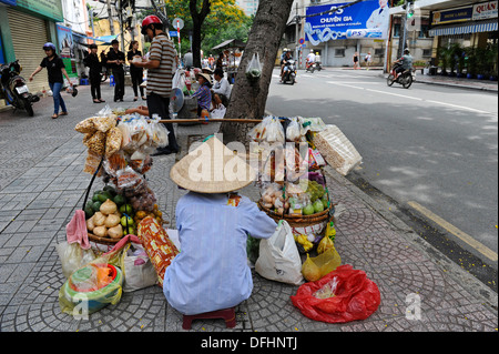 Commerçant de la rue de sexe féminin vente de fruits, noix, etc. en sac à l'adoption du commerce de Ho Chi Minh Ville, Vietnam Banque D'Images