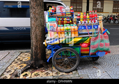 Des rafraîchissements liquides sur un panier sur le côté d'une route achalandée à Ho Chi Minh City, Vietnam. Banque D'Images