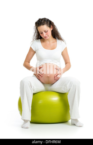 Pregnant woman sitting on fitness ball isolated Banque D'Images