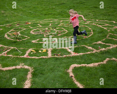 Arnside, Silverdale, UK. 5 octobre, 2013. L'exécution de l'enfant dans l'aire de piscine extérieure circulaire jeu de labyrinthe à Arnside's cinquième journée à Apple de l'AONB Briery Bank Verger, Arnside. Banque D'Images