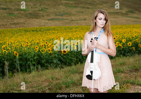 Jeune femme seule est au violon par country road Banque D'Images