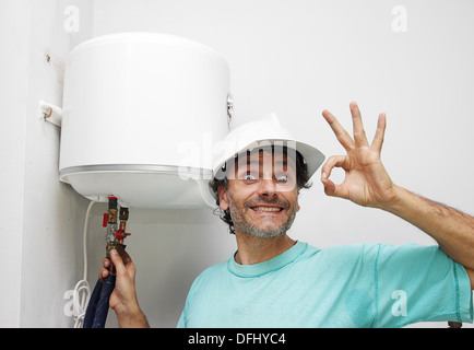 Plombier plaisir l'installation d'un chauffe-eau électrique Banque D'Images