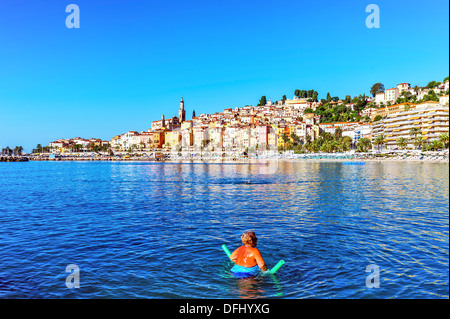 Europe, France, Alpes-Maritimes, Menton. Woman doing exercise la balnéothérapie dans la mer le matin. Banque D'Images