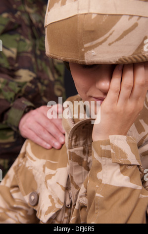 Femme Soldat désemparé être réconforté avec et main sur l'épaule par un soldat de sexe masculin. L'uniforme militaire britannique. Banque D'Images