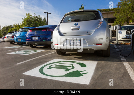Symbole EV peint sur les espaces de stationnement réservés pour les voitures électriques dans un terrain de stationnement de l'entreprise Banque D'Images