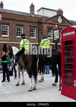 Deux officiers de la police montée à cheval en face d'un pub anglais et une boîte de téléphone rouge Banque D'Images