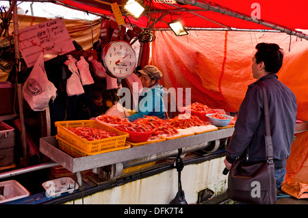 Femme Asiatique d'un poids d'un sac de crevettes pour un client à un marché aux poissons à Fisherman's Wharf, Steveston (Colombie-Britannique), Canada. Banque D'Images