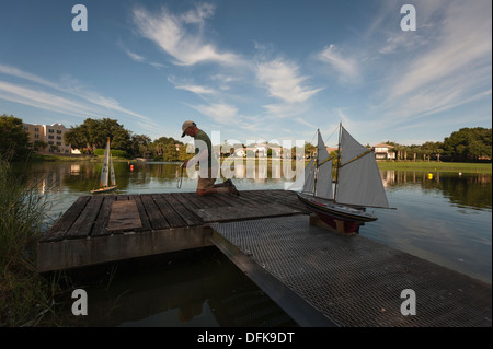 Cadre supérieur retraité citoyen au Villages de la communauté de retraite sa d'exploitation des bateaux de contrôle à distance du rivage. Banque D'Images