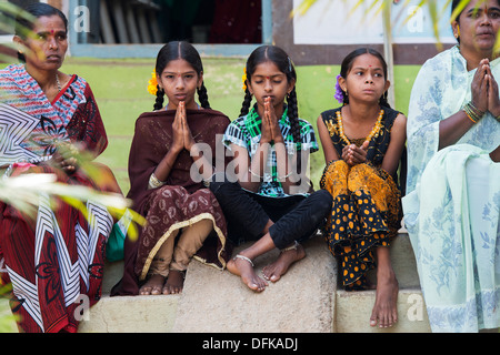 Les filles rurales indiennes priaient à Sri Sathya Sai Baba l'hôpital clinique de services mobiles de proximité. L'Andhra Pradesh, Inde Banque D'Images