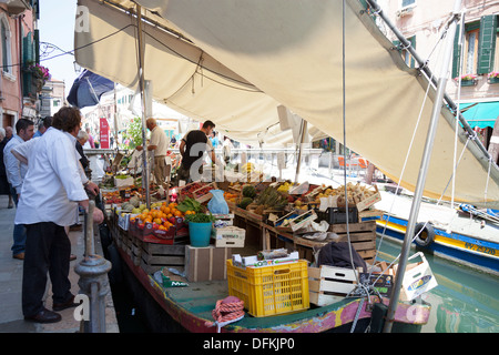 À Venise, un marché flottant d'une barge d'exploitation protégé du soleil par les feuilles (Italie). Marché flottant à Venise (Italie). Banque D'Images