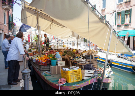 À Venise, un marché flottant d'une barge d'exploitation protégé du soleil par les feuilles (Italie). Marché flottant à Venise (Italie). Banque D'Images