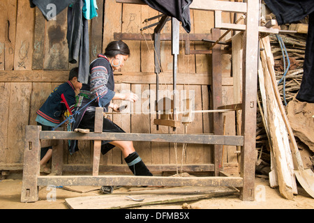 Groupe de la minorité Hmong noir femme montrant comment tisser traditionnel tissage tissu chanvre à Sa Pa, Vietnam Banque D'Images