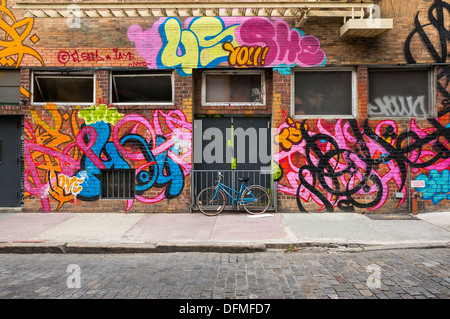 Location reposant contre le graffiti bâtiment couvert dans NYC Banque D'Images