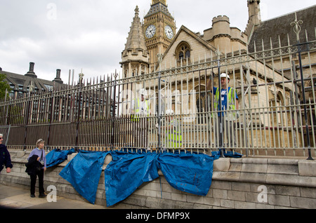 UK, Londres : Ouvriers peindre une clôture montée sur un mur qui entoure le Palais de Westminster à Londres le 7 octobre,201 Banque D'Images