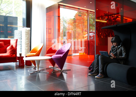 Invité dans le hall avec des meubles design, citoyen M Hotel, Amsterdam, Pays-Bas Banque D'Images
