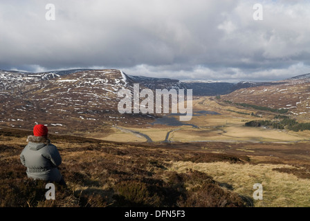 Femme hillwalker admirant la vue sur le Col de Drumochter des pentes du corbett Meall na Leitreach. Banque D'Images