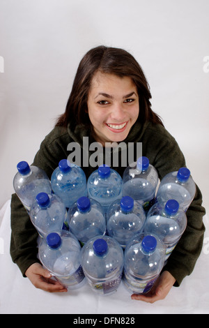 Teenage girl posing avec 12 bouteilles en plastique pour illustrer le recyclage de bouteilles dans un polyester fleece Banque D'Images