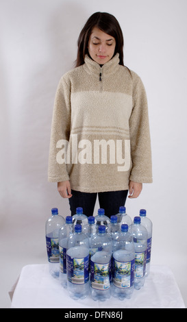 Teenage girl posing avec 12 bouteilles en plastique pour illustrer le recyclage de bouteilles dans un polyester fleece Banque D'Images