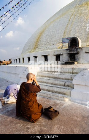 Western nun praying at Bodhnath stupa. Katmandou, Népal Banque D'Images