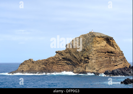 Porto Moniz Madère une petite île rocheuse Islote pier avec petit phare sur elle's Peak Banque D'Images