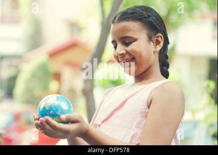 Close-up of a smiling girl holding a globe Banque D'Images