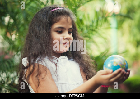 Close-up of a smiling girl holding a globe Banque D'Images