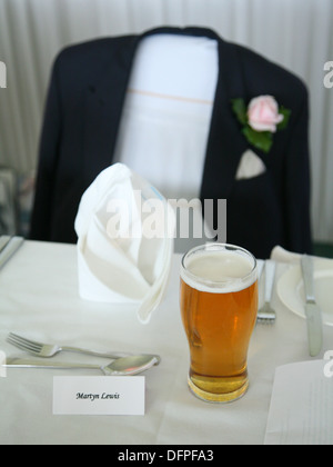 Siège vide et verre sur une table à la réception de mariage, peut-être le marié ou meilleur mans président. Banque D'Images