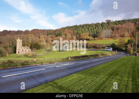 Un entraîneur de Webber qui se déplacent le long de l'A39 à west Quantoxhead, Somerset en Angleterre avec Saint Etheldreda's Church dans la distance. Banque D'Images