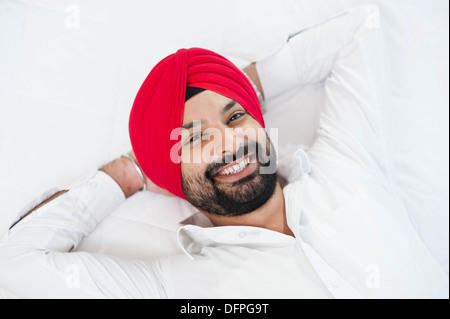 Close-up d'un Sikh couché sur le lit et souriant Banque D'Images