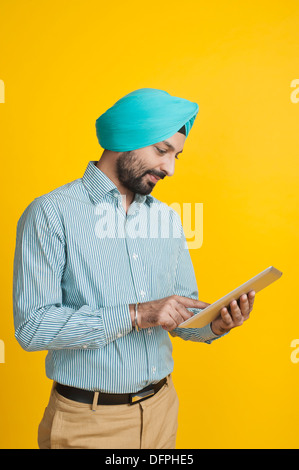 Homme Sikh à l'aide d'une tablette numérique Banque D'Images