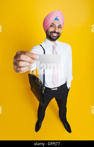 Businessman showing a blank business card and smiling Banque D'Images