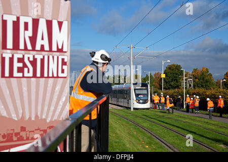 Edinburgh, Ecosse, Royaume-Uni. 8 octobre 2013. Test de tramway se déroule à travers la région d'Edinburgh Park/Gyle et continuera jusqu'à ce que le service de tramway à l'essai commence en mai 2014. Entouré de nombreux techniciens le tramway fait son chemin lentement à travers le test route l'arrêt intermittent de chèques. Banque D'Images