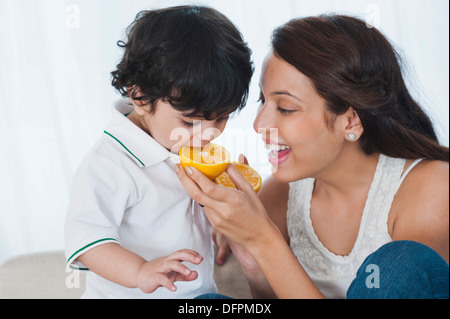 Woman feeding orange pour son fils Banque D'Images