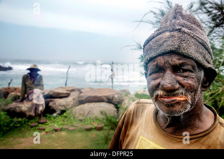 Pêcheurs sur pilotis poteau ou dans le Sri Lanka Mirissa pêcher assis sur une planche en bois appelée petta attaché à une perche verticale Banque D'Images