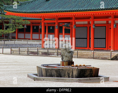 Une photo d'une fontaine en forme de dragon en pierre caractéristique de l'architecture Shinto japonais avec en arrière-plan Banque D'Images