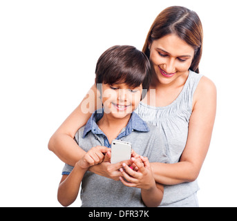 Femme et de son fils la messagerie texte sur un téléphone mobile et souriant Banque D'Images