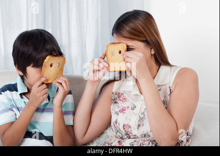 Femme et son fils à la recherche à travers des trous de pains Banque D'Images