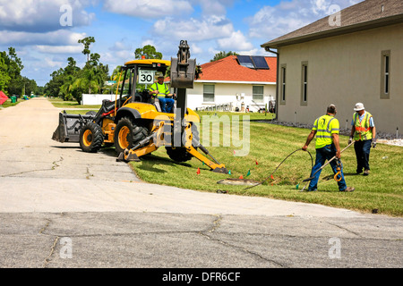 Travaux publics travailleurs Dept creuser et remplacement d'une évacuation d'eau de pluie bloqués dans un quartier résidentiel de Floride Banque D'Images