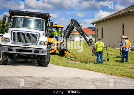 Travaux publics travailleurs Dept creuser et remplacement d'une évacuation d'eau de pluie bloqués dans un quartier résidentiel de Floride Banque D'Images