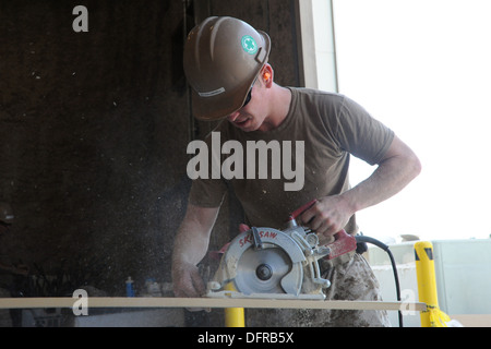 L'aérodrome de Kandahar, Afghanistan - US Navy Builder 1re classe Mark Campbell, attaché à la construction navale (bataillon Mobile NMCB) 28, coupe du bois pour être utilisé comme un moulage dans de nouveaux espaces de bureaux, le 2 octobre 2013. 28 NMCB est basée à base aérienne de Barksdale, SHR Banque D'Images