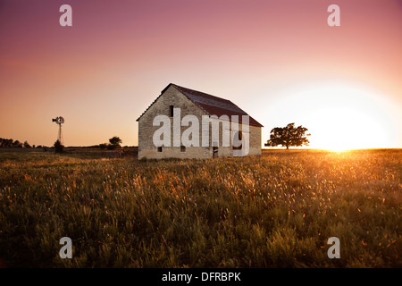 Une grange en pierre s'deglected au coucher du soleil. dans les collines du sud de silex Kansas, USA. Banque D'Images