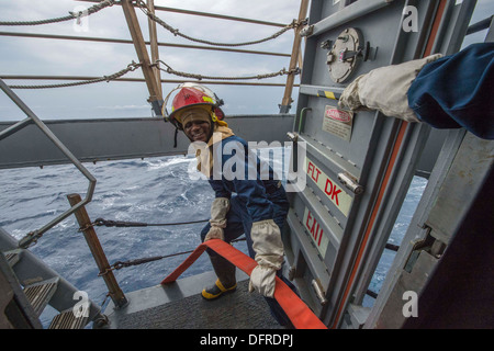 Seaman Jarren Waller mans un tuyau d'incendie au cours d'un exercice général quarts à bord du quai de transport amphibie USS New Orleans Banque D'Images