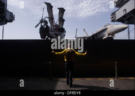 Maître de Manœuvre de l'aviation (manutention) 2e classe Christopher O'Neil des signaux à soulever un avion ascenseur dans la zone du porte-avions USS Harry S. Truman (CVN 75). Harry S. Truman, navire amiral de la Harry S. Truman Strike Group, est depl Banque D'Images