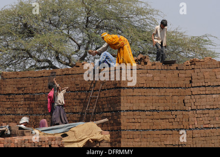 L'homme et la femme tribal Bareli travailleurs brique Définition des couches de briques. Banque D'Images
