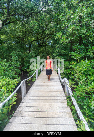 Jeune femme se promène le long de la demande par l'intermédiaire de mangrove, à Kosrae Micronésie. Banque D'Images