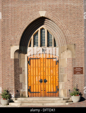 Porte d'entrée en bois avec garnitures décoratives dans arch chaped renfoncement du mur de l'Église catholique à Hoogmade, Pays-Bas Banque D'Images