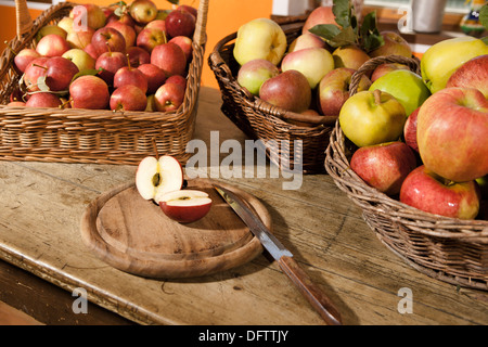 Récolte des pommes, différentes variétés de pommes dans des paniers, disposés sur une table, avec du miel et de la confiture Banque D'Images