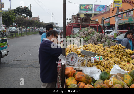 Les ananas et les bananes en vente à partir de l'arrière d'un camion en face d'un marché dans le quartier de Los Olivos Lima, Pérou Banque D'Images